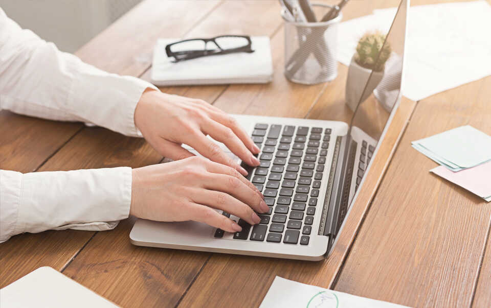 kobieta pisząca na laptopie